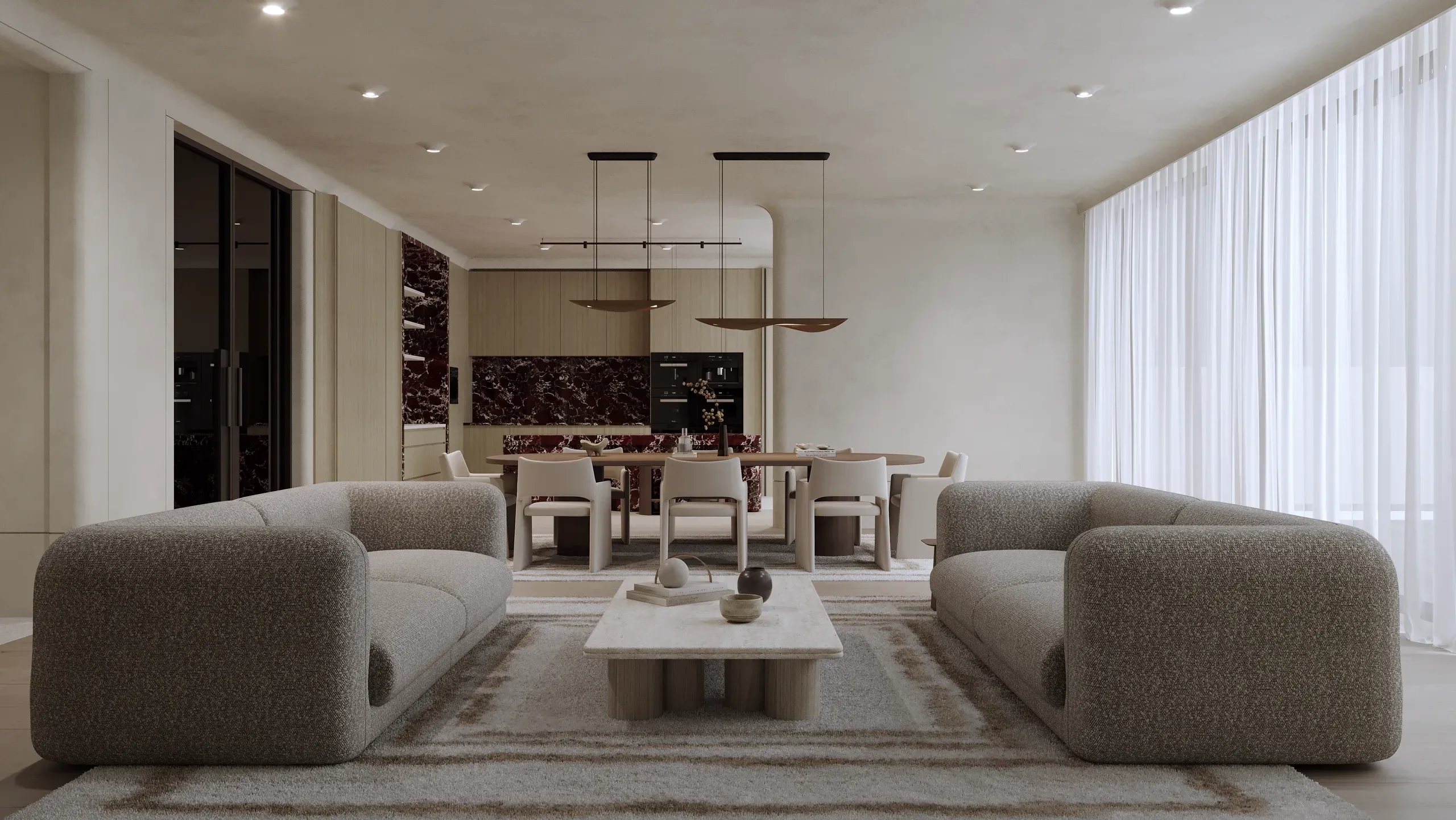 Modern open-plan living and dining space with curved gray sofas, wood dining table, dark marble kitchen backsplash, and pendant lighting.