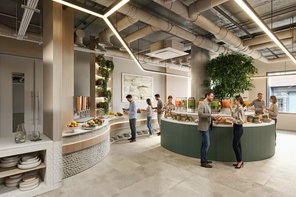 Modern office break room with curved green counter, exposed ceiling ducts, skylights, planted walls, and employees socializing near food stations.