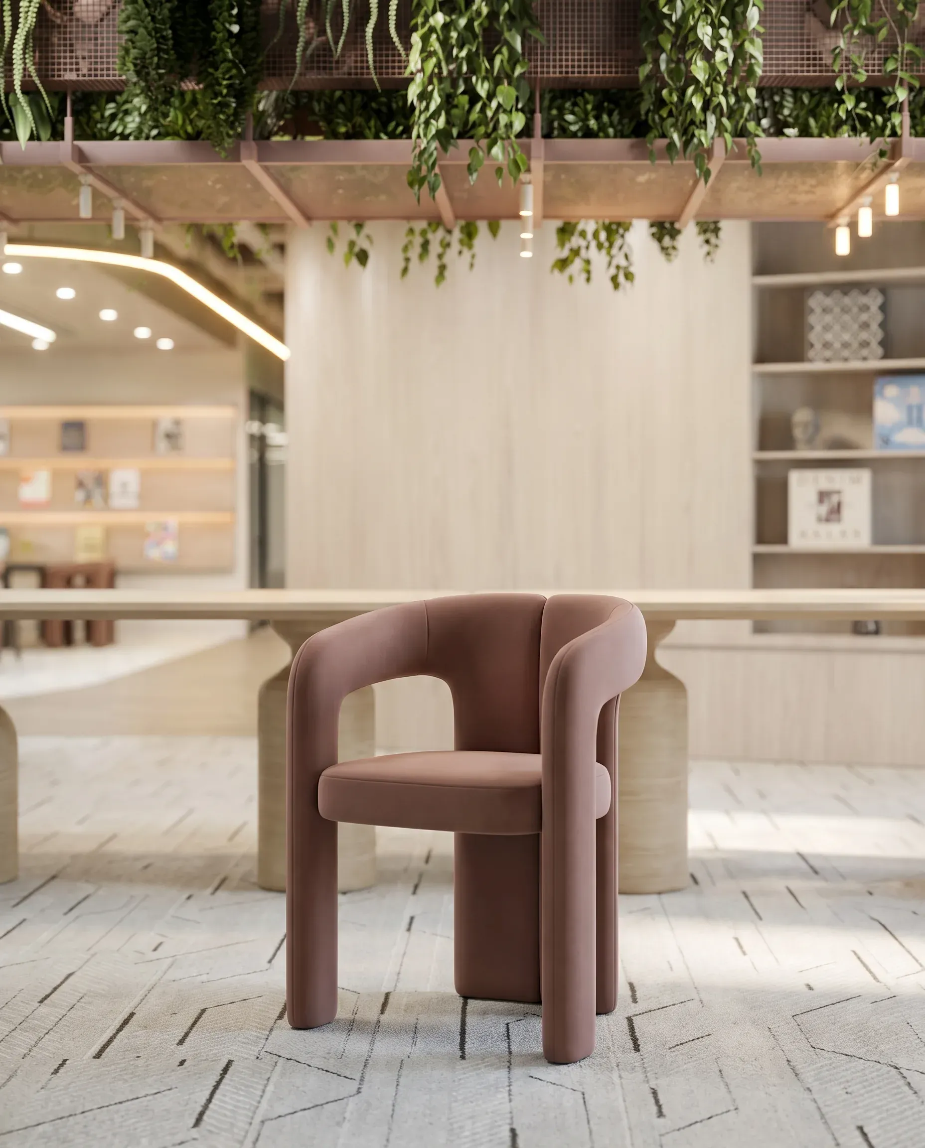 Modern mauve armchair in minimalist interior with hanging plants, wooden beams, and built-in shelving.