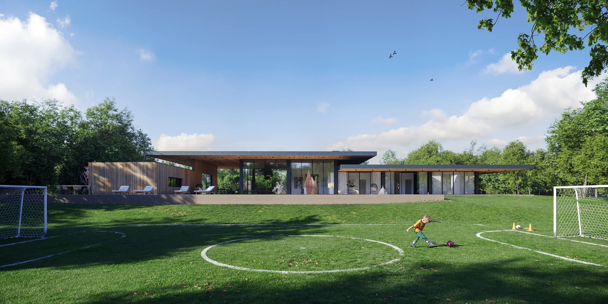 Modern residential home with large glass windows, wooden cladding, and open lawn with soccer field markings and goals.