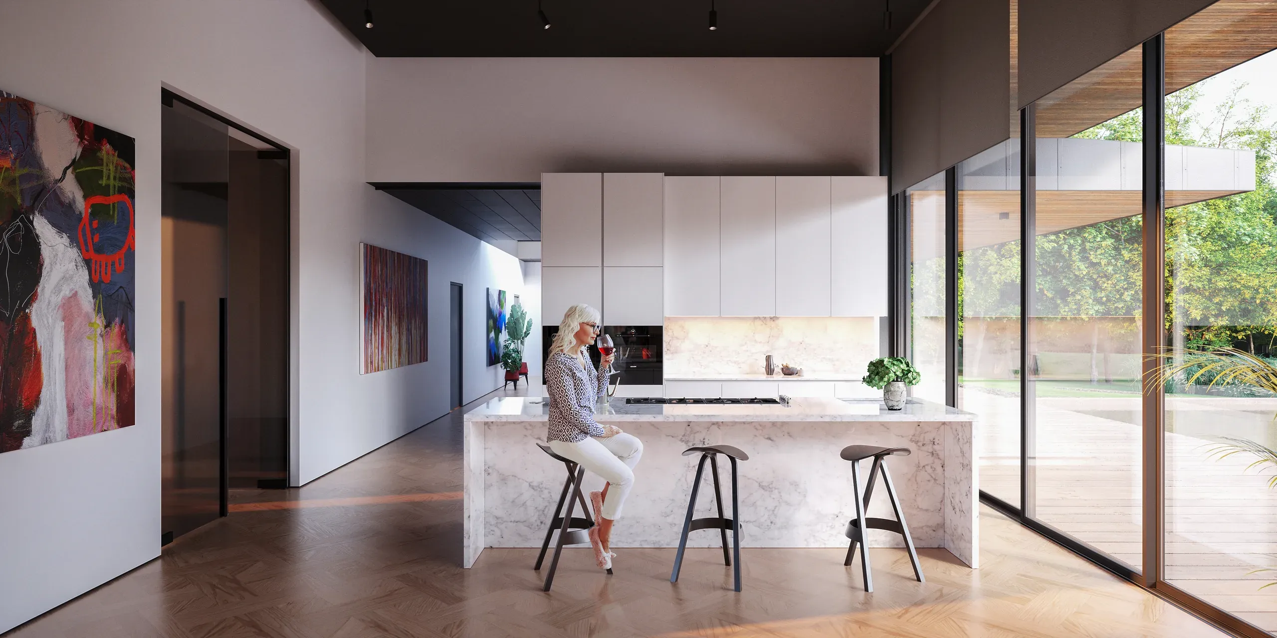 Modern kitchen with marble island, white cabinetry, and large windows overlooking garden. Woman seated at bar with three stools.