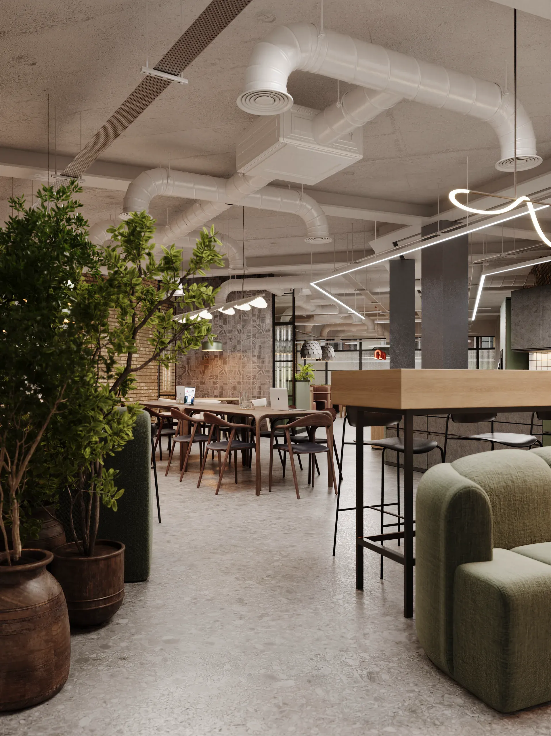 Modern office break room with concrete ceiling, exposed ductwork, neon lighting, wooden dining table, green upholstered seating, potted plants, and brick accent wall.