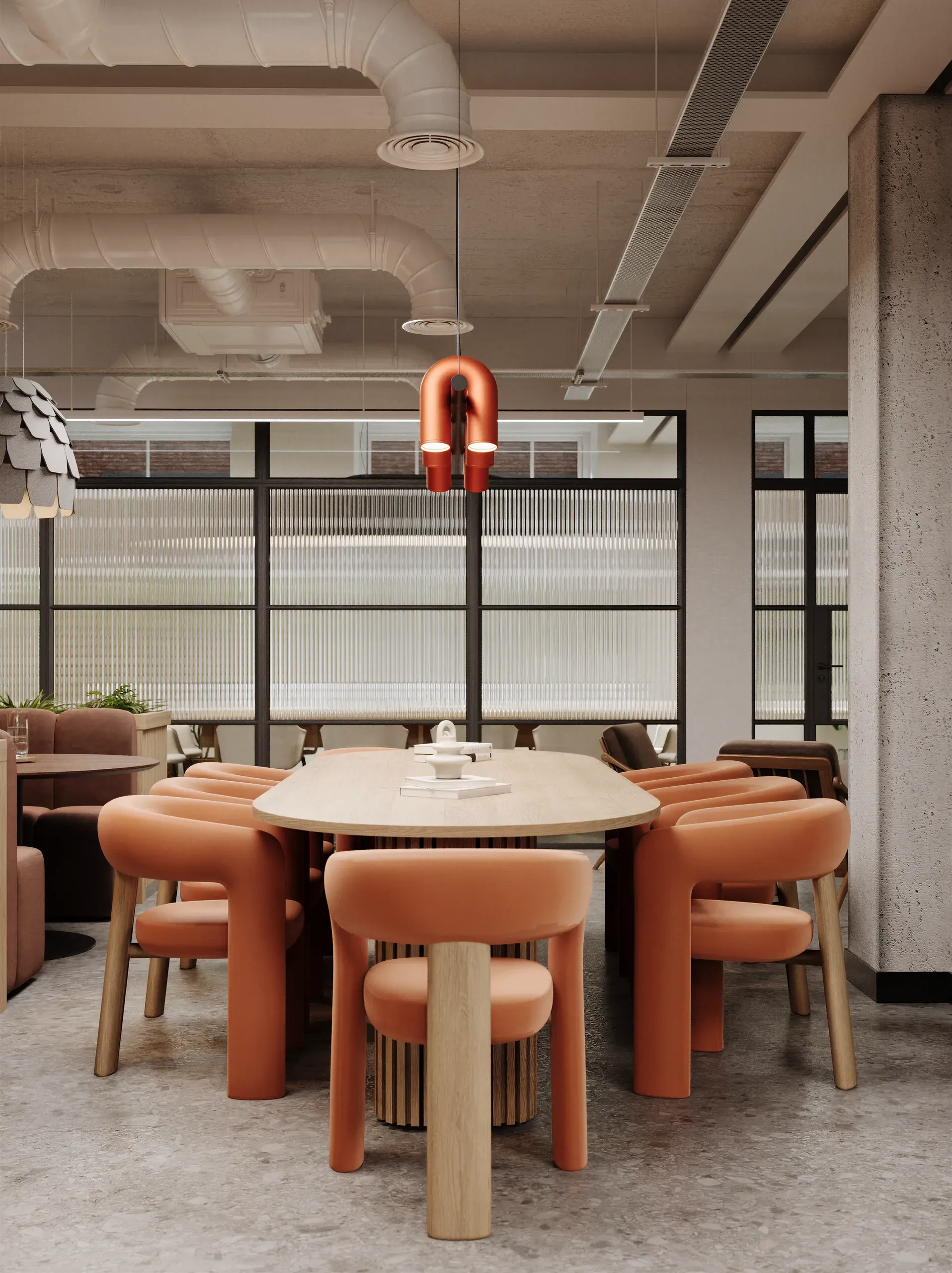 Modern office meeting space with round table, orange chairs, exposed ceiling ducts, pendant light, and floor-to-ceiling windows with blinds.