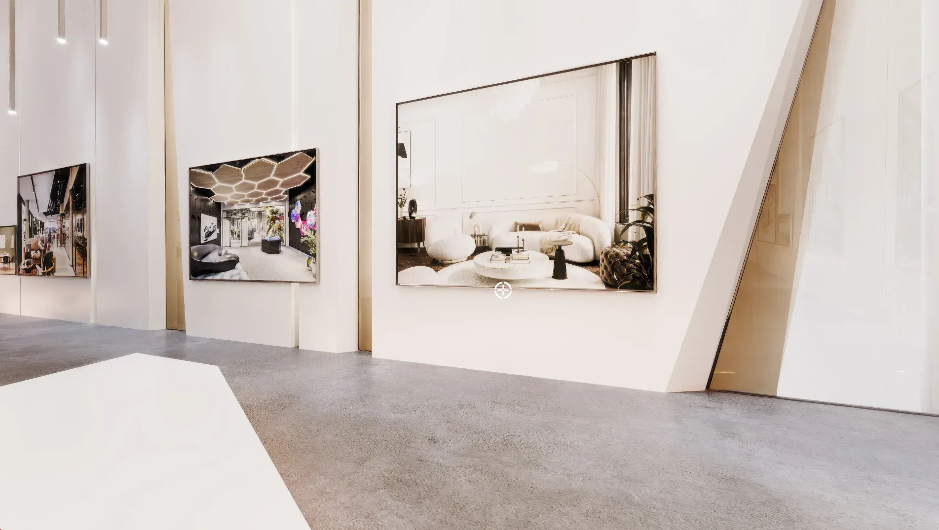 Modern showroom interior with framed architectural renderings displayed on white walls, polished concrete floor, and gold metal accents.